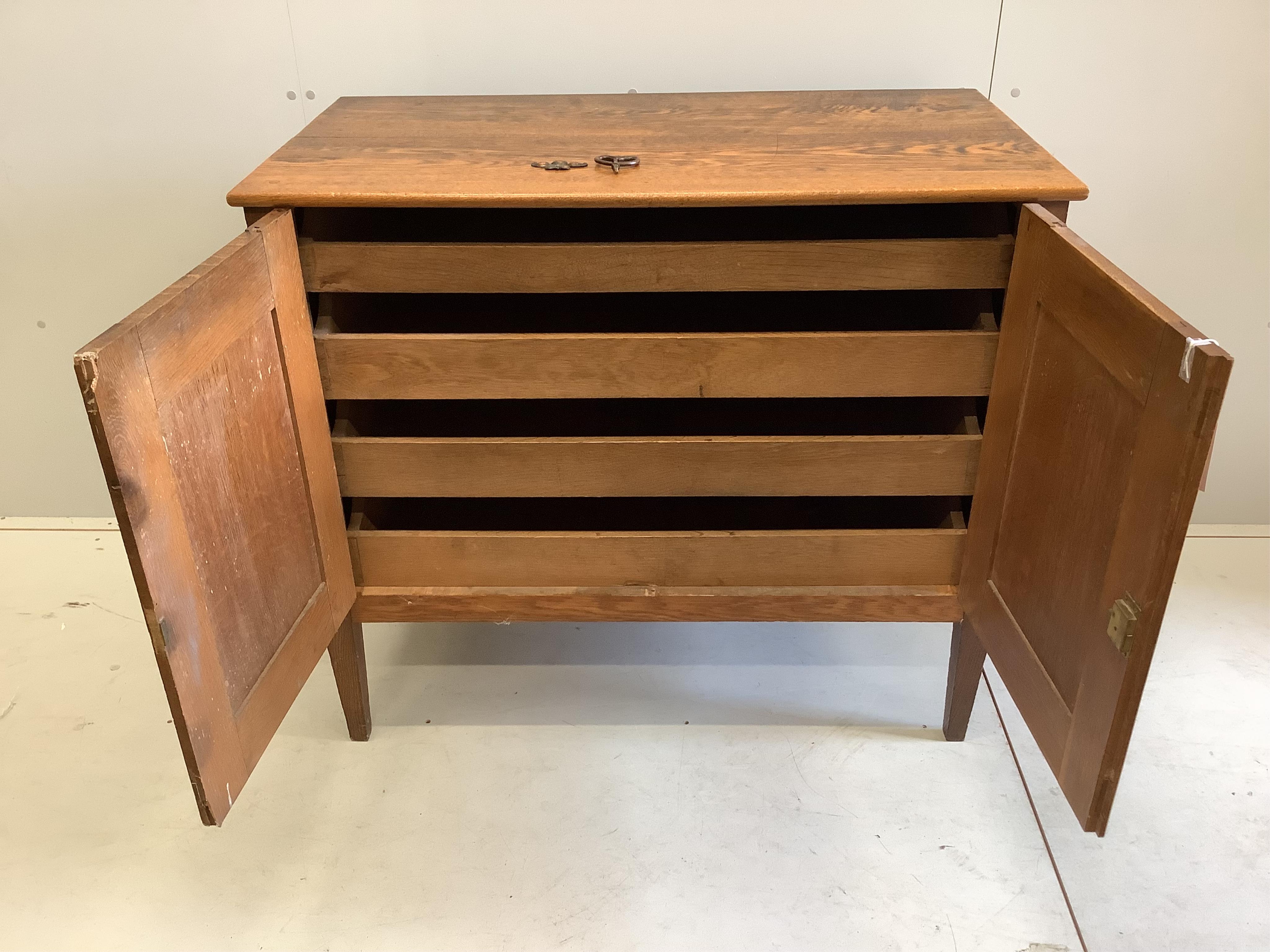 An early 20th century Continental oak press cupboard, width 106cm, depth 58cm, height 92cm. Condition - fair